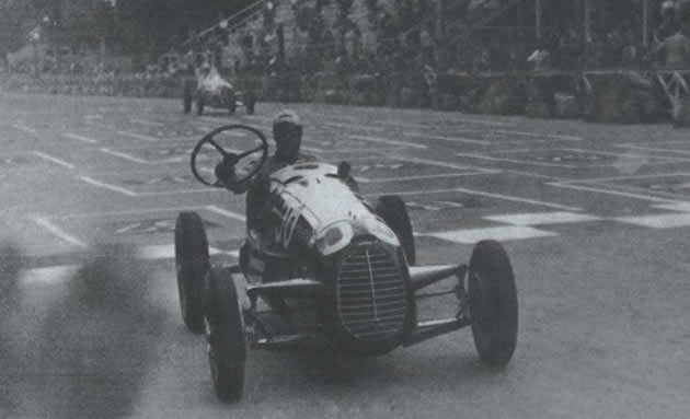 Tazio Nuvolari taglia il traguardo al Valentino reggendo il volante in mano